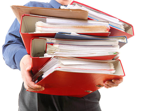 istock Male office worker carrying a stack of files 506495179