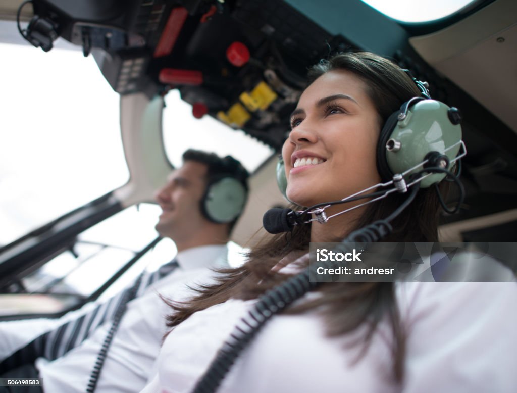 Woman flying a helicopter Woman flying a helicopter with her copilot Pilot Stock Photo