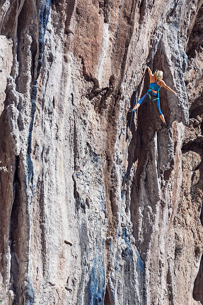 istock Young Rock Climber ascending steep colourful rocky Wall Lead Climbing 506503116
