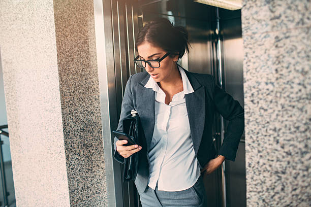 istock Businesswoman Texting  In The Elevator 506503466