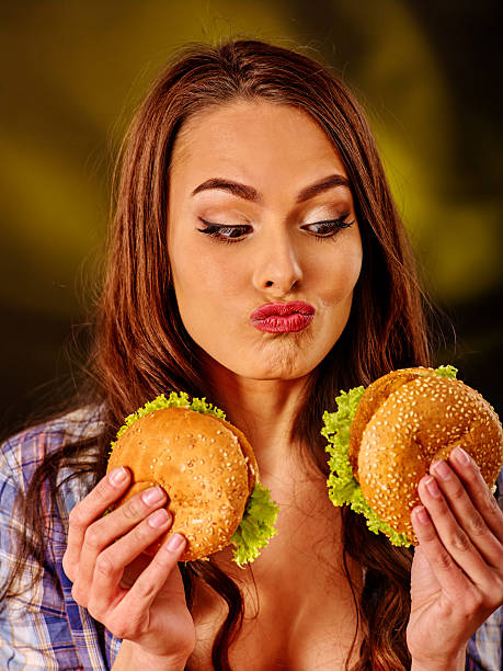 istock Girl eating big sandwich 506504772