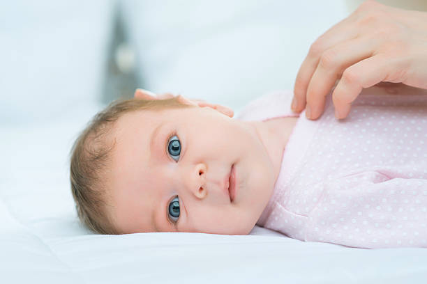 istock Nursing mother putting her little child in bed 506505010