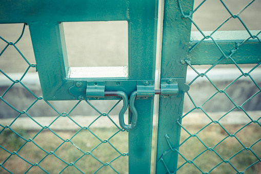 Green metal fence lock with pastel tone