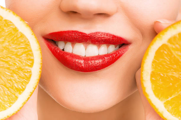 ragazza holding arance - human lips orange lipstick human mouth foto e immagini stock