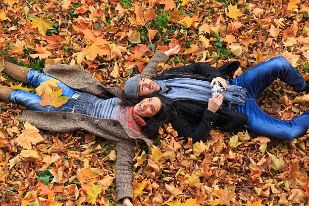 istock Young couple having fun and  lying down on leaves 506508036