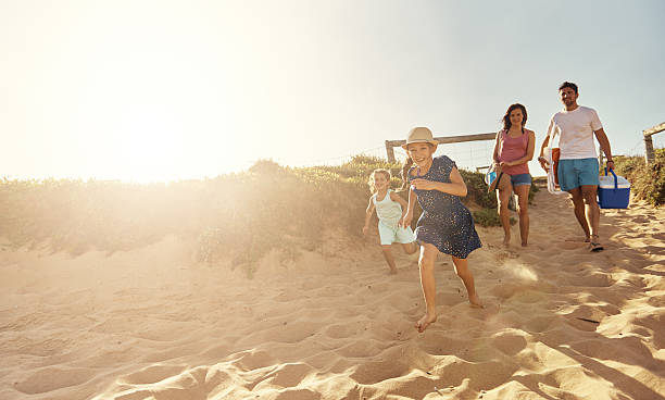 Beach your children well Shot of a young family arriving at the beachimage806237.jpg beach fun stock pictures, royalty-free photos & images