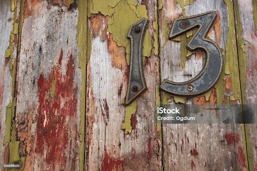 Number 13 Number 13 written on a very old wood with ripped of paints.  Friday the 13th Stock Photo