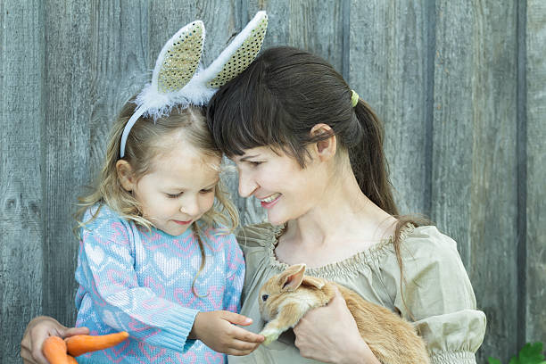 istock Mother and her child holding cute scarlet Easter rabbit 506509026