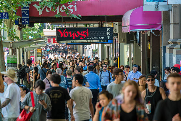 People walking along a busy street in Melbourne Melbourne, Australia - Dec 16, 2015: People walking along a busy street in downtown Melbourne, Australia melbourne street crowd stock pictures, royalty-free photos & images