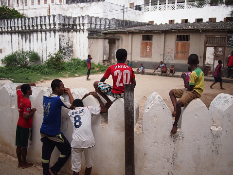 A team of soccer players and their coach enjoy healthy oranges for their half time snack during their friendly game amongst themselves. Soccer practice at a rural school near Cape Town, South Africa