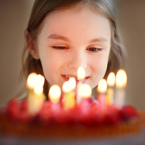 istock Adorable little girl and a raspberry cake 506512216
