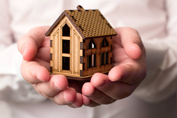 istock small wooden house in male hands 506514848
