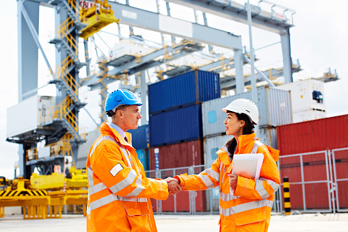 Portrait of two workers shaking hands on a commercial dock