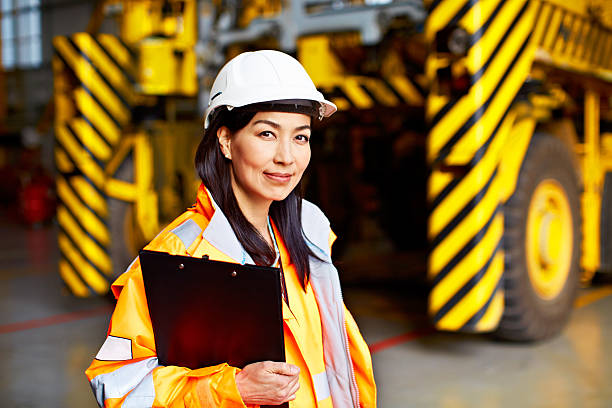 Global shipping is our business Shot of a woman in workwear standing in a large industrial building asian female engineer stock pictures, royalty-free photos & images