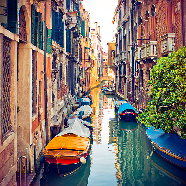 Narrow canal with parked boats in Venice