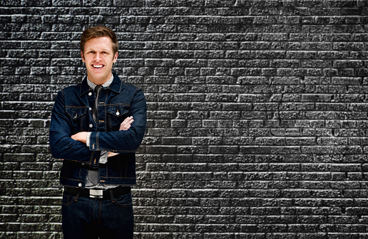 Smiling smart casual man in front of brick wallhttp://www.twodozendesign.info/i/1.png