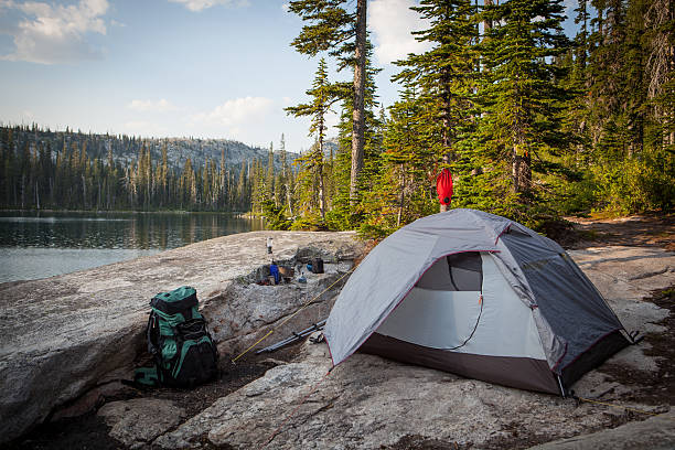 Tent pitched alongside a mountain lake. stock photo