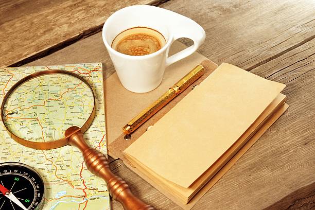 istock Compass Magnifier Vintage Notepad Gold Pen Coffee Cup Wood Table 506541129