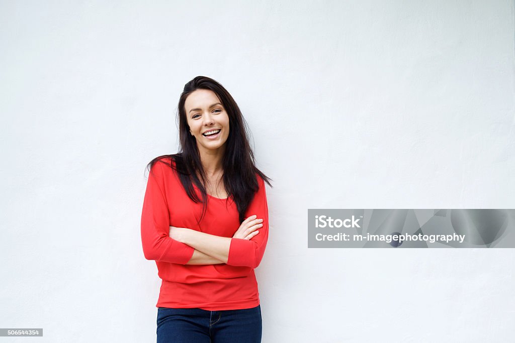 Smiling young woman in red shirt smiling against white background Portrait of a smiling young woman in red shirt smiling against white background Women Stock Photo