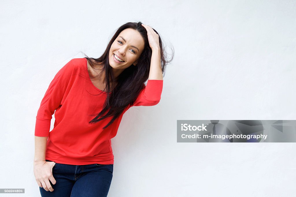 Smiling young woman with hand in hair Portrait of a smiling young woman with hand in hair Hand In Hair Stock Photo