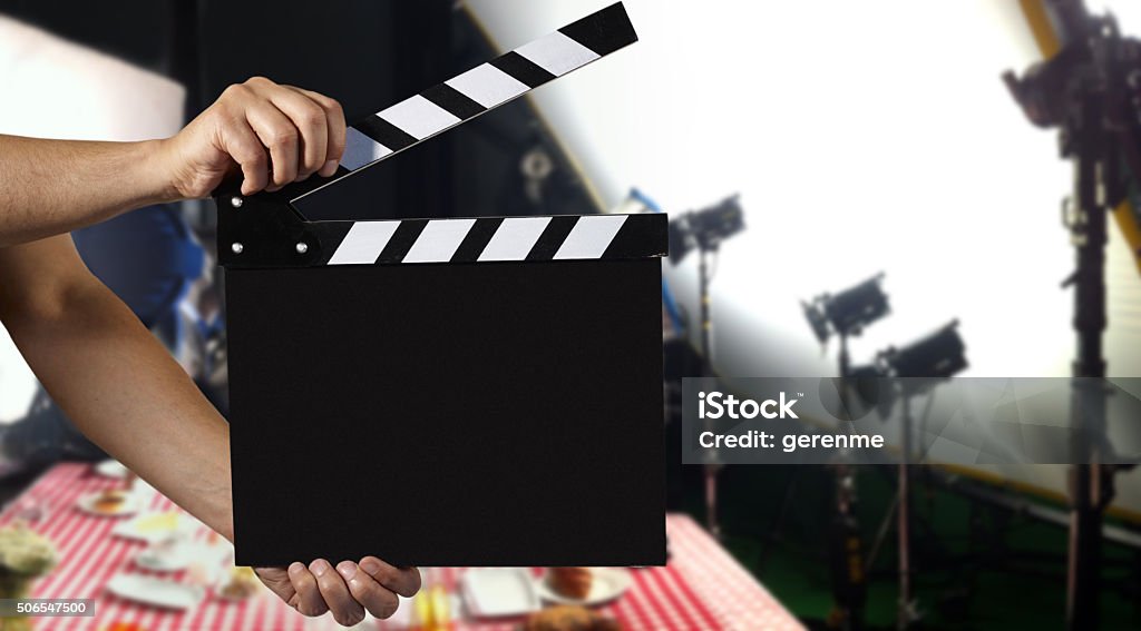 Man holding a clapper Man holding film slate on a film set Home Video Camera Stock Photo