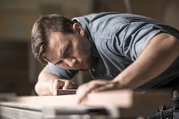 istock Joinery worker smoothening wood piece 506547812