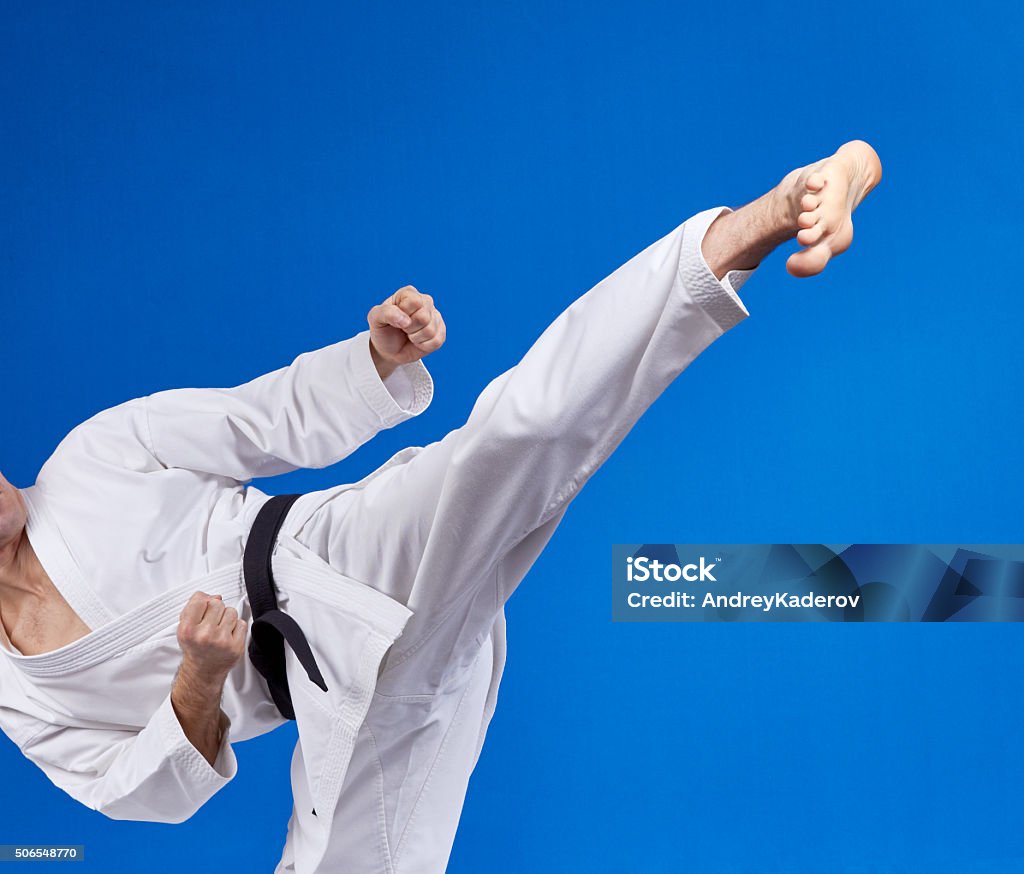 High kick athlete is beating with a black belt Activity Stock Photo