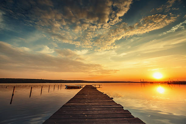 istock Boat and jetty on lake with water reflection 506549214