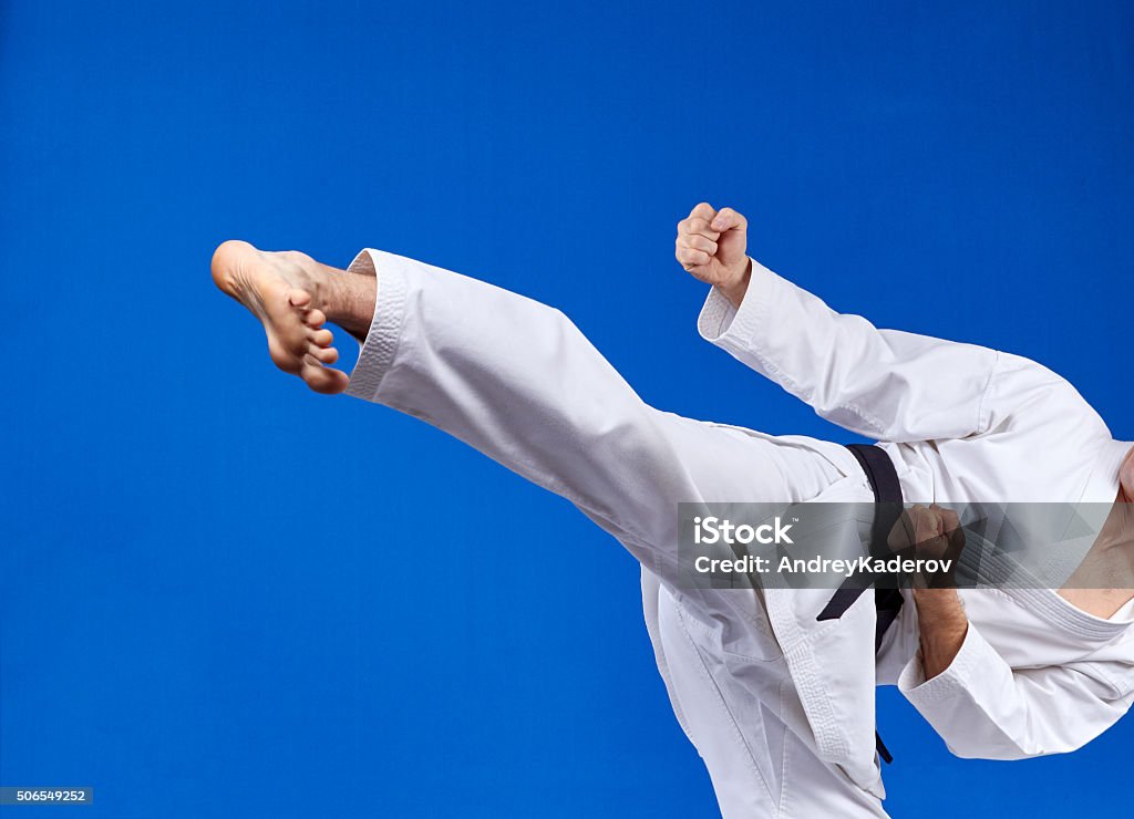 On a blue background athlete beats kicking Activity Stock Photo