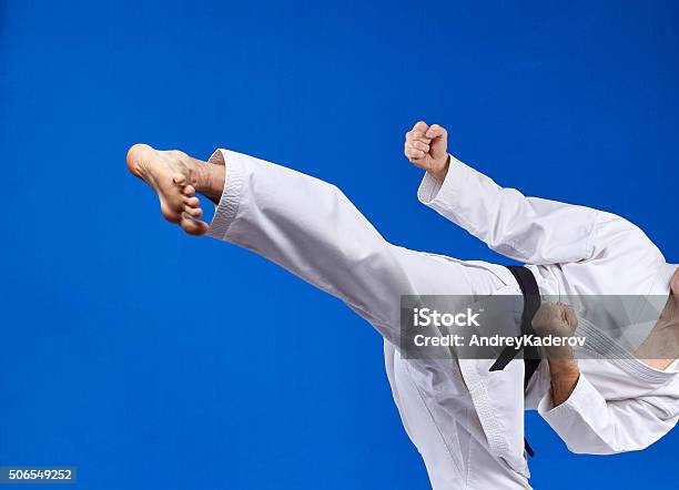 On A Blue Background Athlete Beats Kicking Stock Photo - Download Image Now - Activity, Adult, Authority