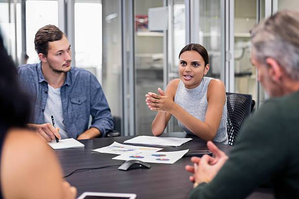 Aboriginal business woman talking in a meeting Business people on a meeting in the office, Aboriginal business woman is talking to her colleagues about the new project. aborigine woman stock pictures, royalty-free photos & images