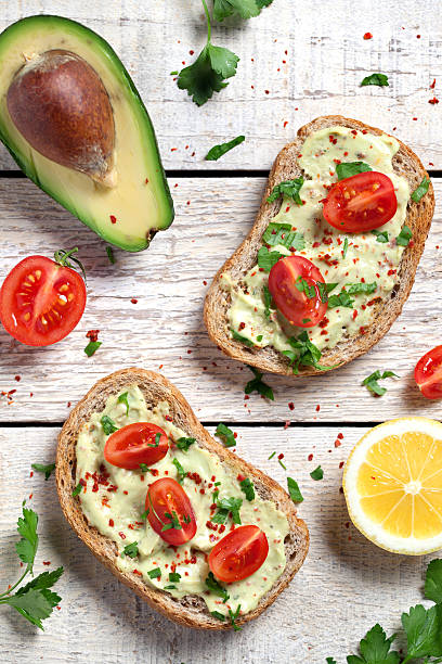 Healthy whole grain bread with avocado Healthy whole grain bread with avocado and cherry tomatoes spread food stock pictures, royalty-free photos & images