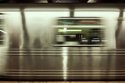 An abstract shot of a moving subway car with slow shutter in order to get motion blur on the train, cross proceed color added.