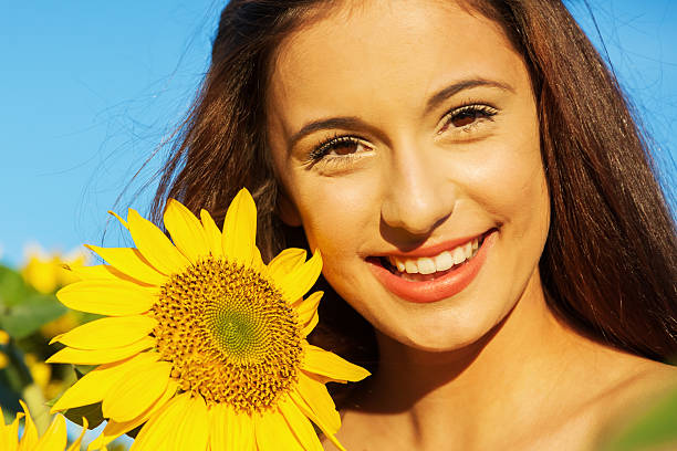 istock pretty young girl with sunflowers 506555292