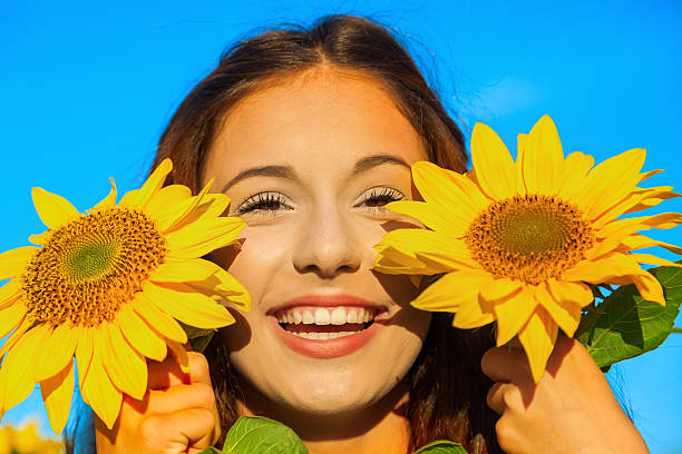 istock pretty young girl with sunflowers 506555432
