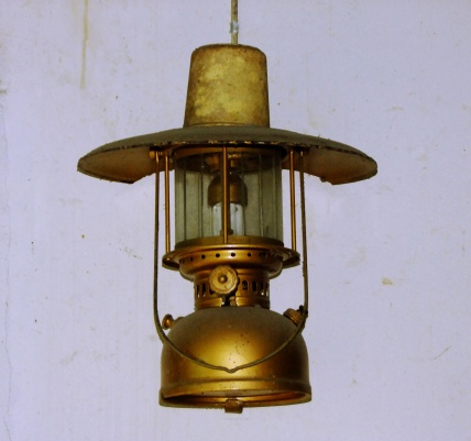 A kerosene lamp illuminating the darkness. A vintage lamp hangs in an old house.