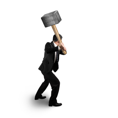 Businessman holding big hammer isolated in white background