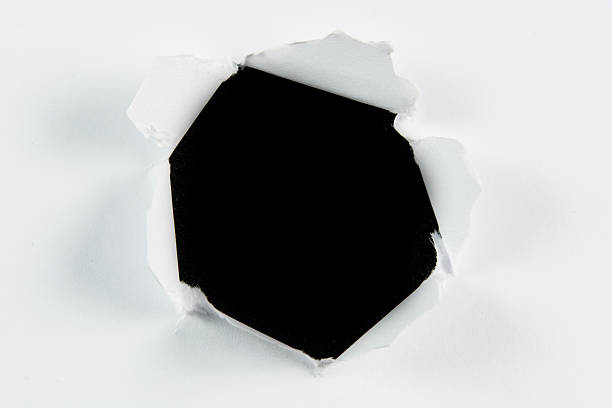 istock Breakthrough torn big black hole in white paper 506575155