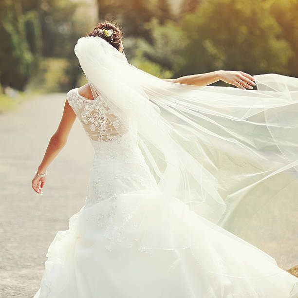istock happy brunette bride spinning around with veil 506575605