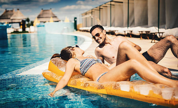 istock Couple relaxing at swimming pool. 506582948