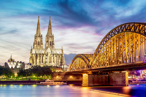 Illuminated Dom in Cologne with bridge and rhine at sunset