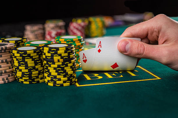 игрок в покер мужского пола, поднимая углах две карты тузы - professional dealer стоковые фото и изображения