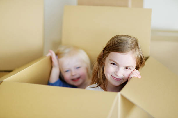 istock Two cute sisters moving in her new home 506587010