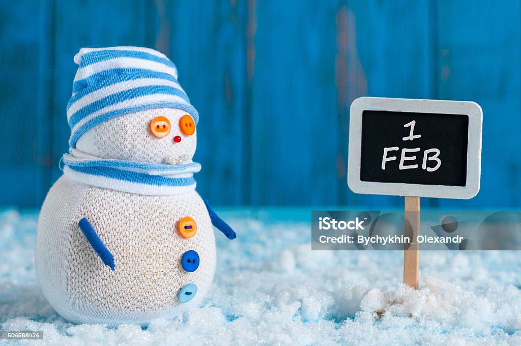 Signpost of the 1 February and Snowman  stand near direction Signpost of the 1 February and Snowman  stand near direction sign. Happy winter postcard . 2016 Stock Photo