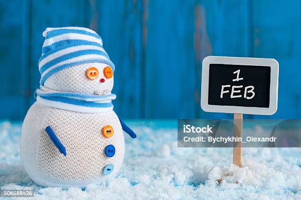 Signpost Of The 1 February And Snowman Stand Near Direction Stock Photo - Download Image Now