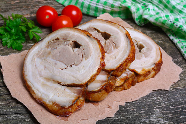 istock Sliced roasted roll pork loin with spices and fresh vegetables 506589158