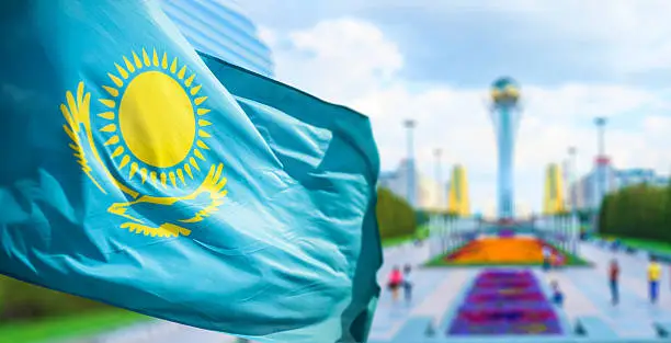 Wind develops flag of the Republic of Kazakhstan in bacground Astana
