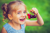 Little girl with a cherry