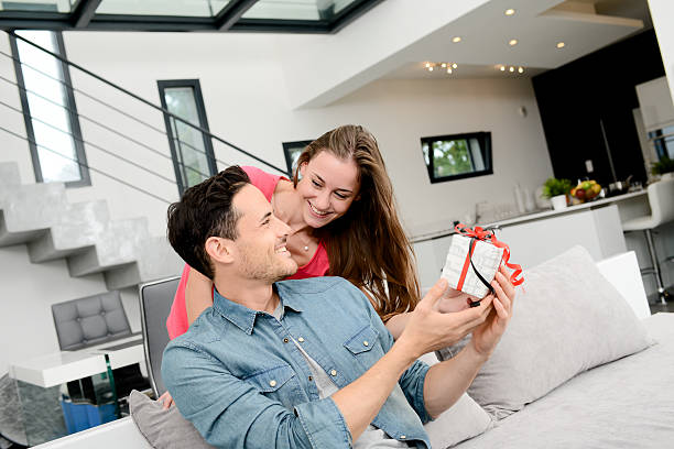 istock cheerful young couple offering gift birthday present or valentines day 506592370