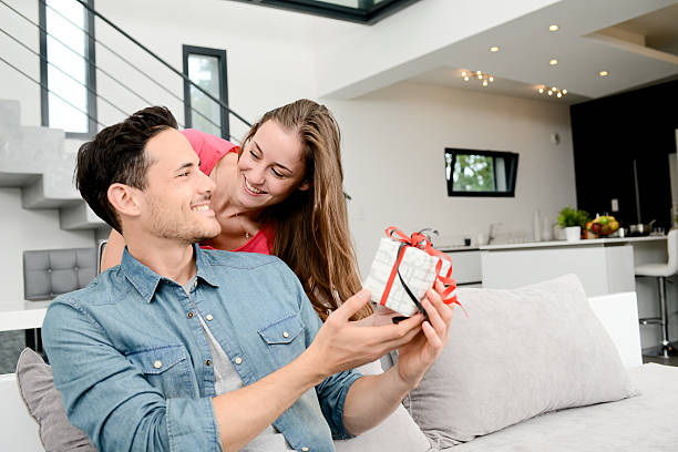 istock cheerful young couple offering gift birthday present or valentines day 506592936
